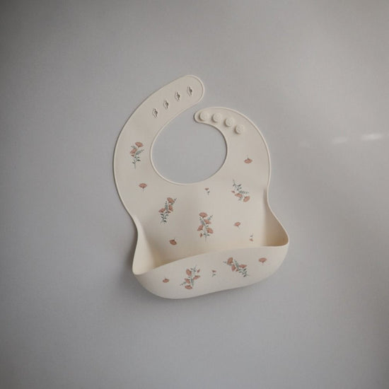 https://www.vanastenbabysuperstore.nl/media/catalog/product/8/2/8292110038_2_slabber_mushie_siliconen_pink_flowers.jpg