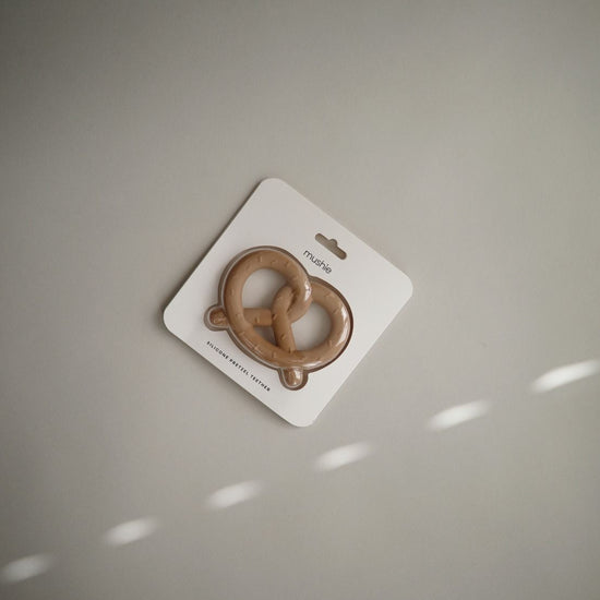 https://www.vanastenbabysuperstore.nl/media/catalog/product/8/2/8292110043_2_bijtring_mushie_pretzel_natural.jpg